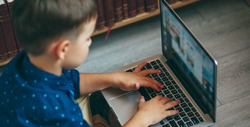 Young boy playing on laptop