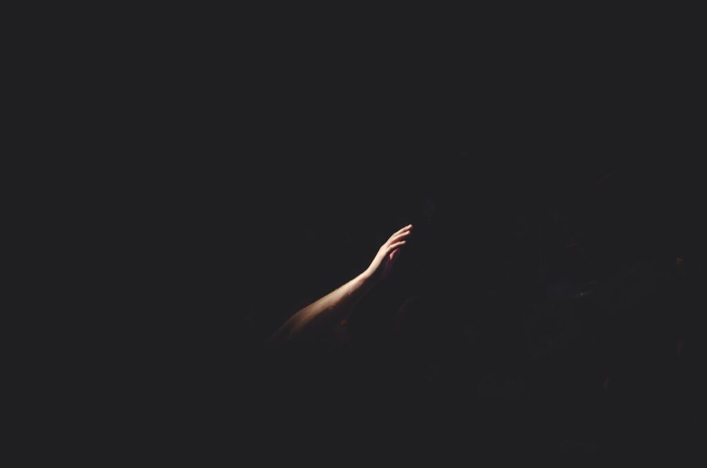 Hand reaching out in the darkness