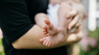 Newborn being held baby feet