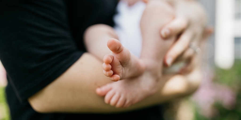 Newborn being held baby feet