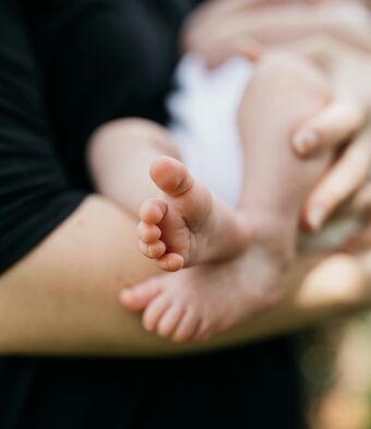 Newborn being held baby feet