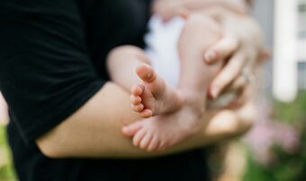 Newborn being held baby feet