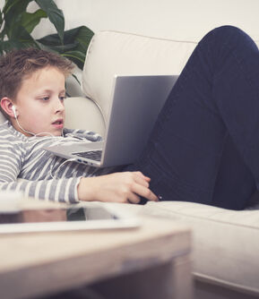 Young boy on laptop online gambling