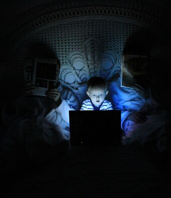 Child on computer in darkness