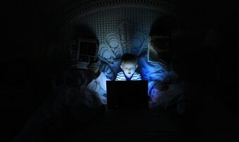 Child on computer in darkness