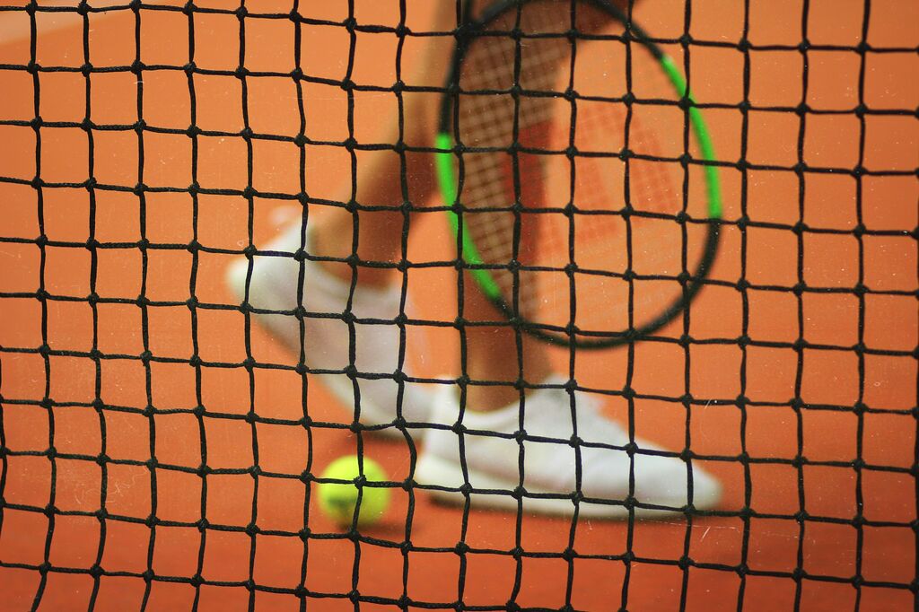 Tennis player legs behind net