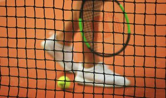 Tennis player legs behind net
