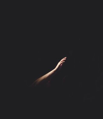 Hand reaching out in the darkness
