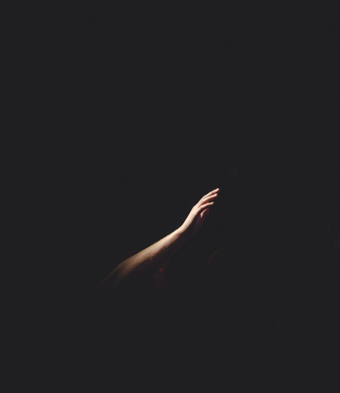 Hand reaching out in the darkness