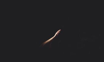 Hand reaching out in the darkness