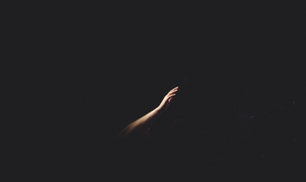 Hand reaching out in the darkness