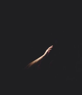 Hand reaching out in the darkness