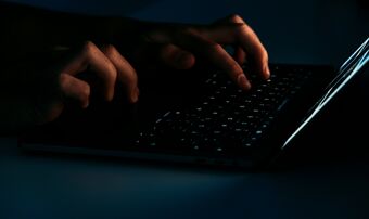 Hands typing on dark keyboard