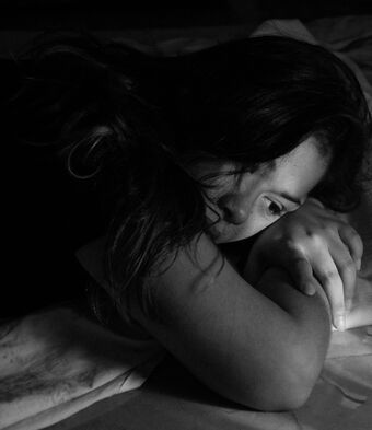 Sad woman lying in bed