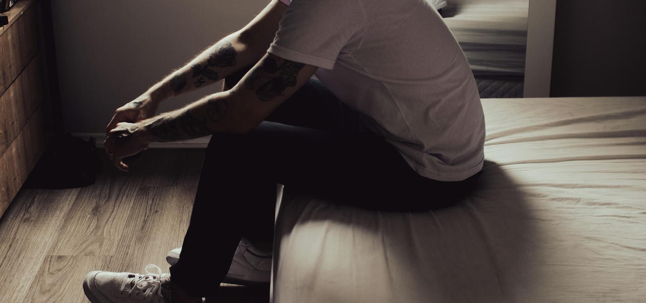 Man sad sitting on bed