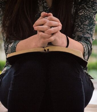 Woman seated bible prayer